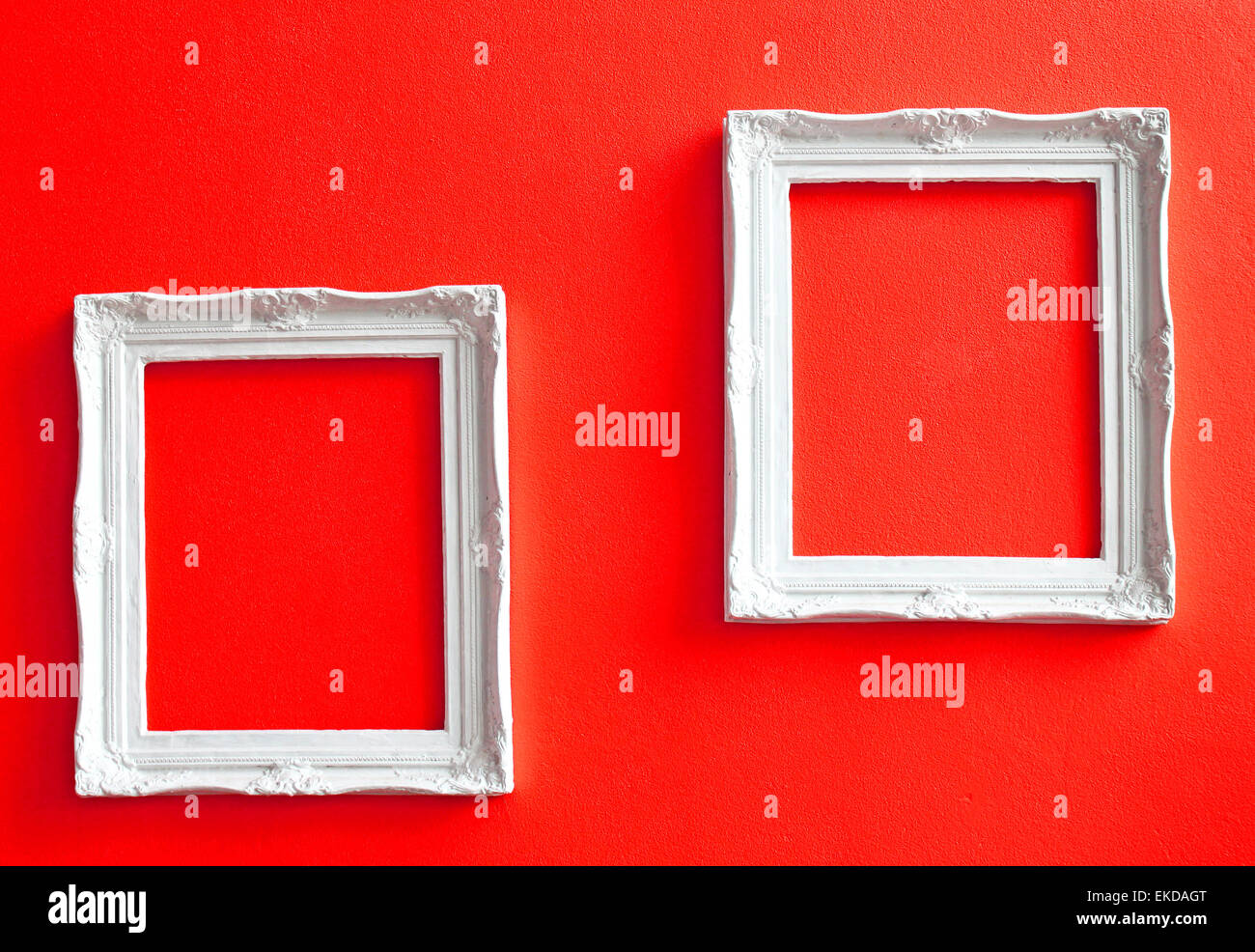 Two white vintage frames on red wall Stock Photo