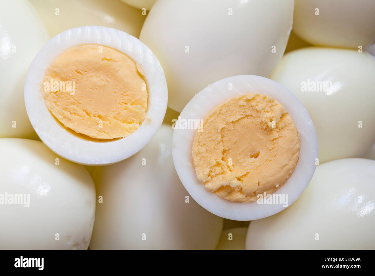 peeled hard boiled eggs with one cut in half on top Stock Photo