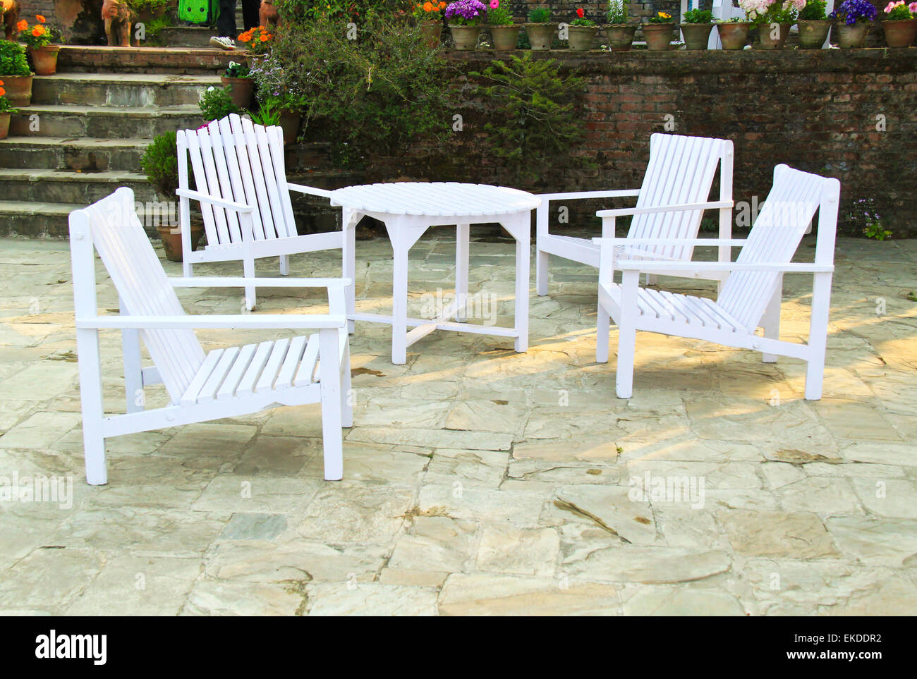 White chairs and table in a garden Stock Photo - Alamy