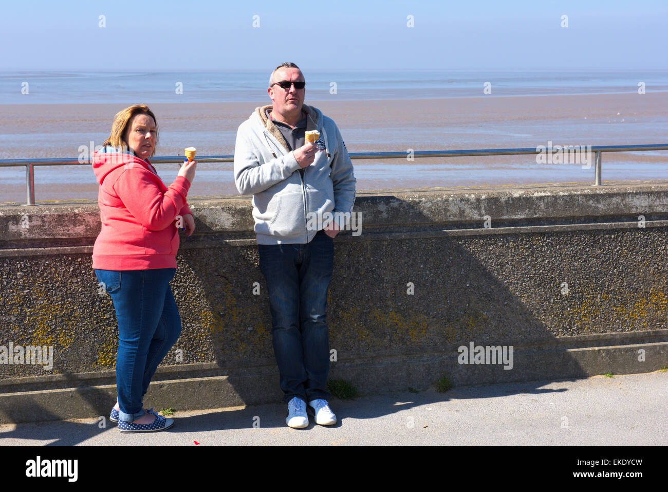 Couple on promenade with ice creams by beach front Burnham-on-Sea, Somerset Stock Photo