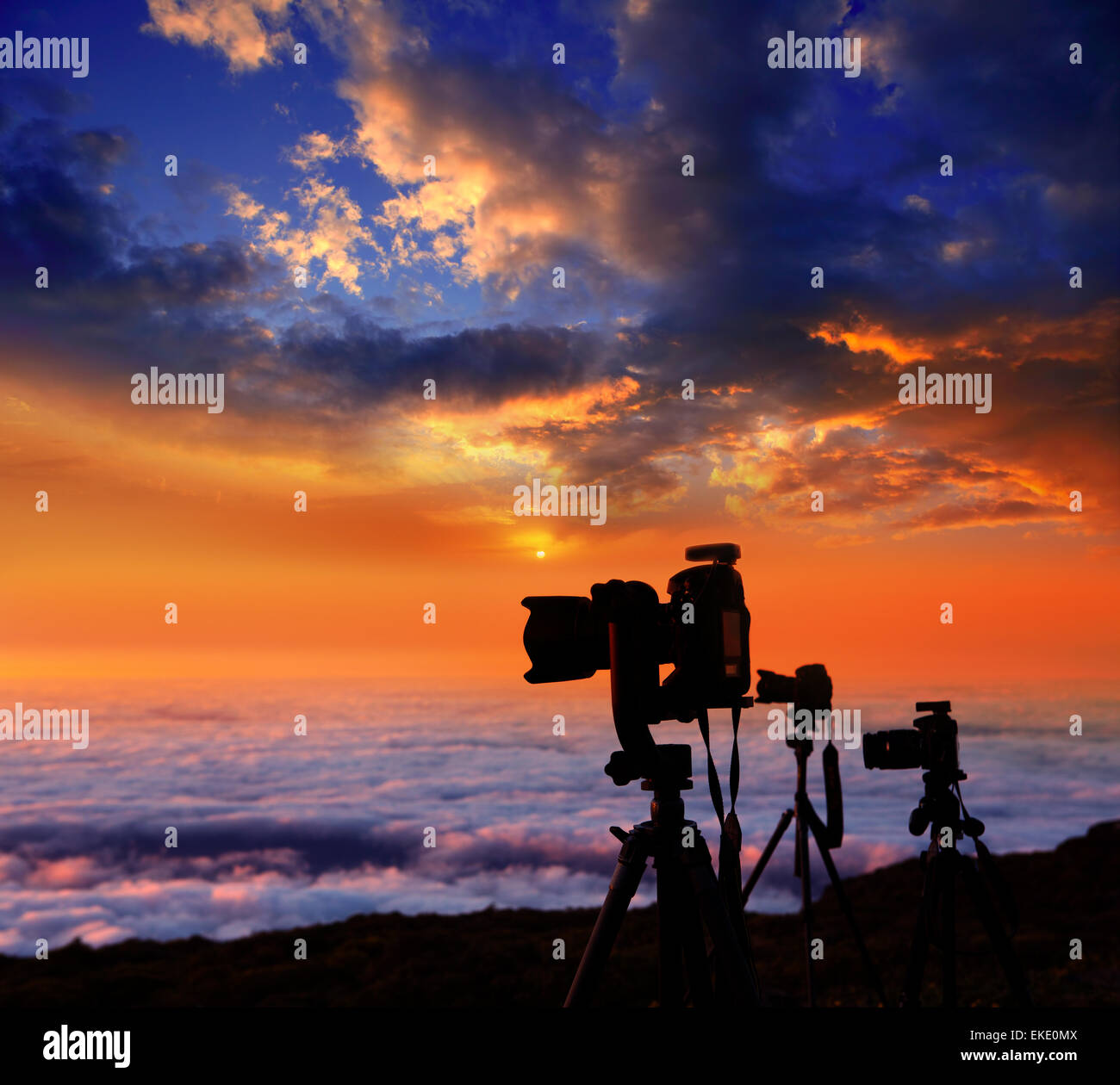 camera tripods photographer sunset sea of clouds Stock Photo - Alamy