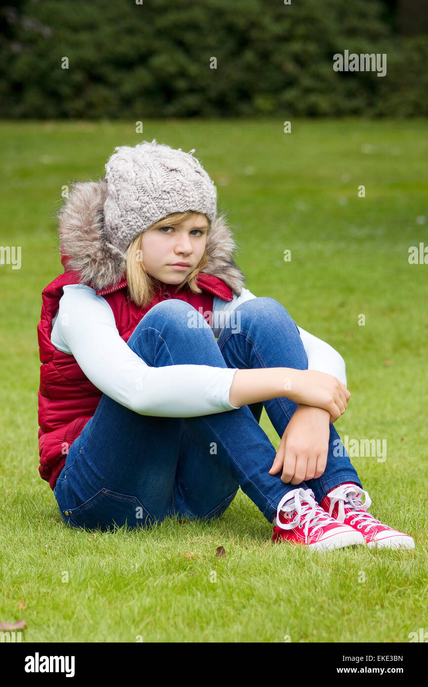 young girl sitting on the grass in the park Stock Photo - Alamy