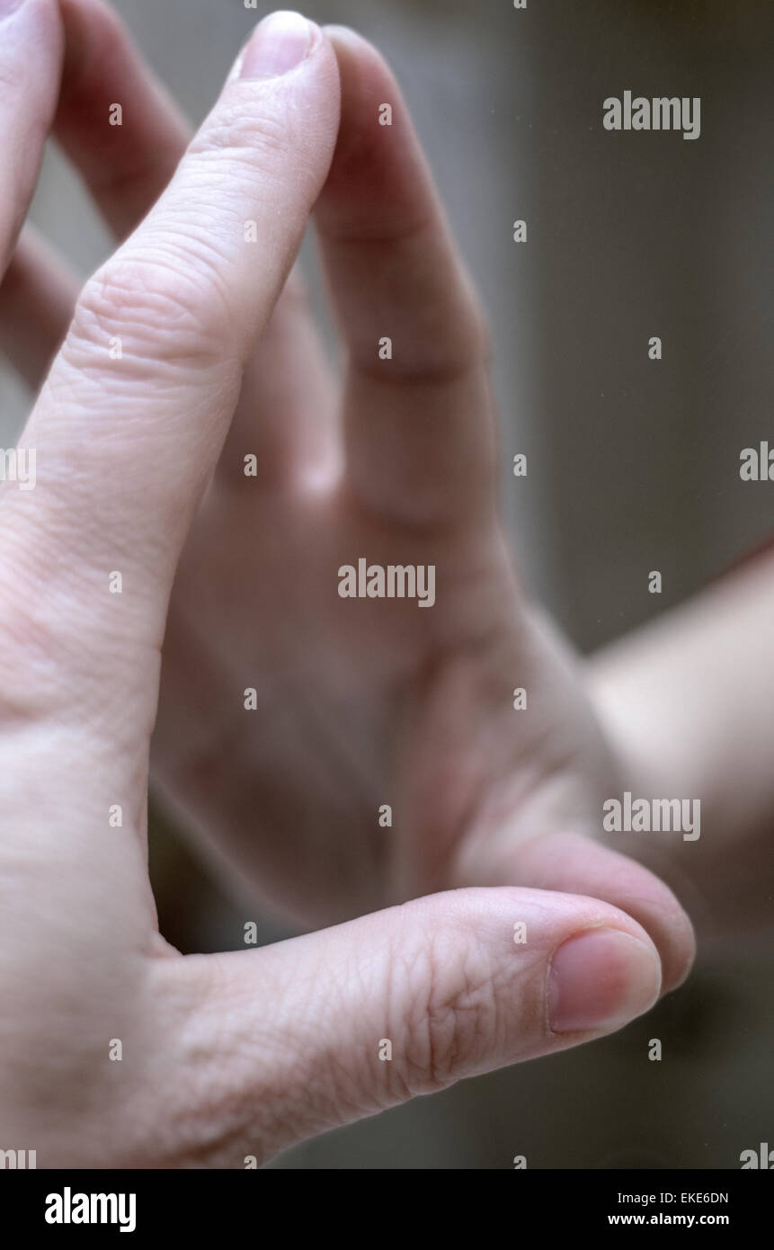 Close up of a woman's hand reflected in a mirror. Stock Photo