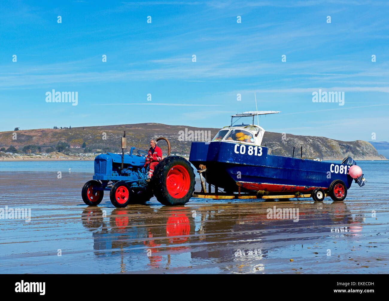Tractor pulling boat, on trailer, onto beach, Abersoch, Gwynedd, North Wales UK Stock Photo