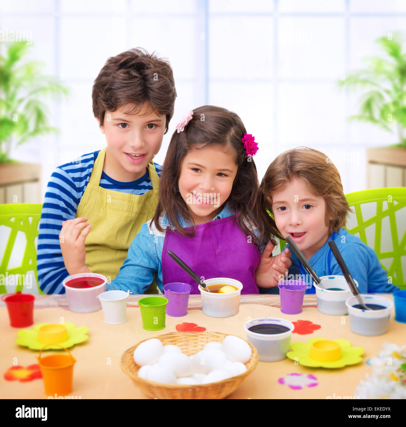 Portrait of cute cheerful kids paint eggs at home, happy Easter tradition, celebrating Christian holiday with pleasure Stock Photo