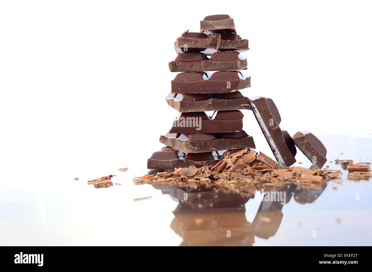 Stack of chocolate on reflective glass against white background. Stock Photo