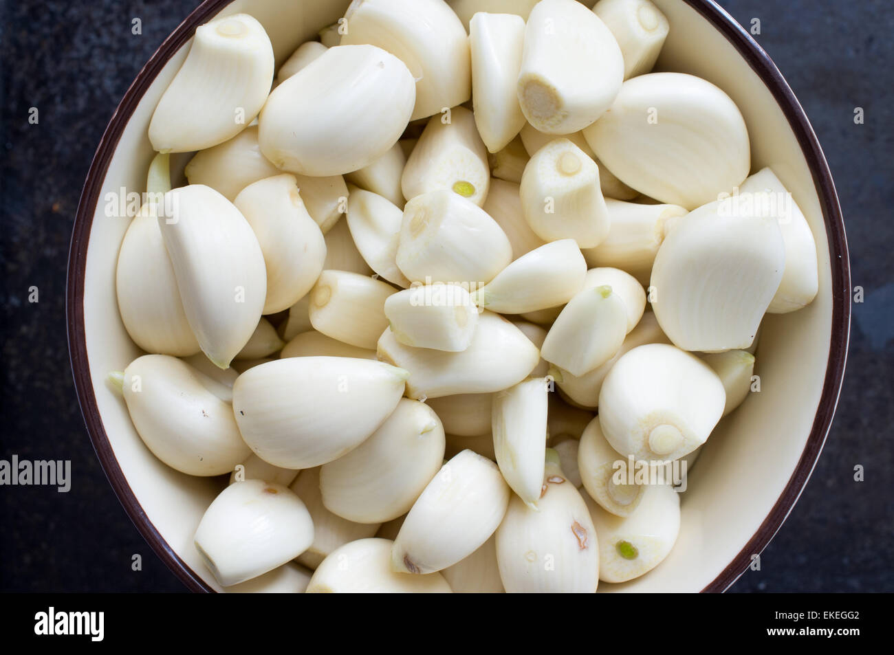 Peeled garlic cloves in a bowl top view Stock Photo