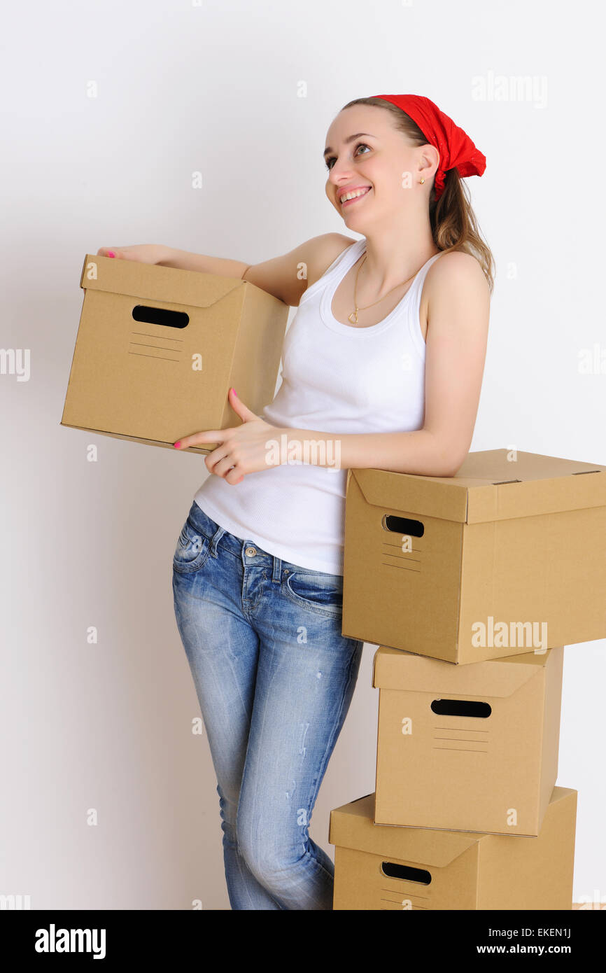 A Smiling Young Woman Opening Cardboard Box With A Box Cutter At
