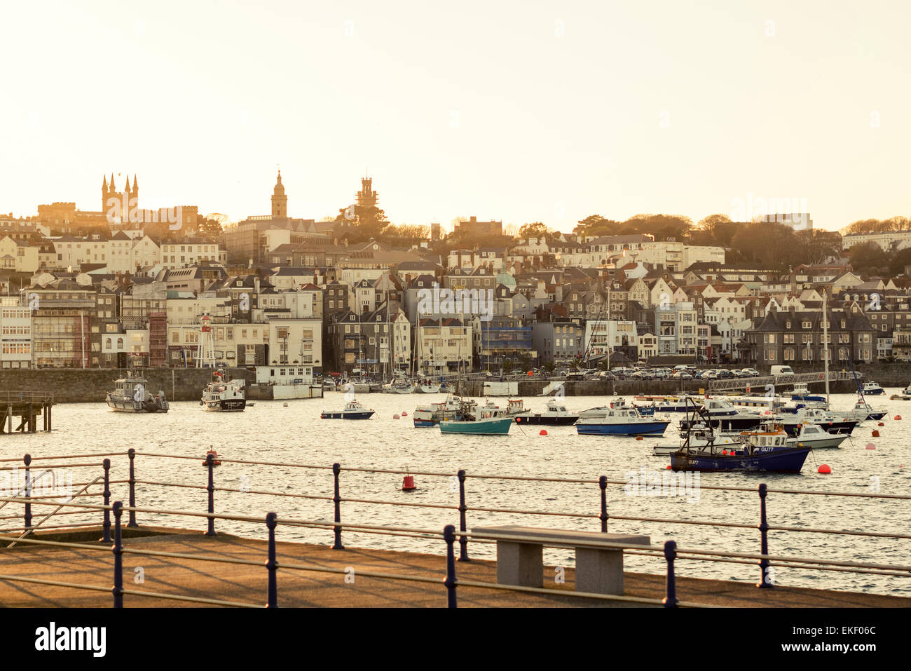 St Peter Port, capital of the Island Guernsey. Warm sunset, looking west over the harbor with fishing boats and town houses. Stock Photo