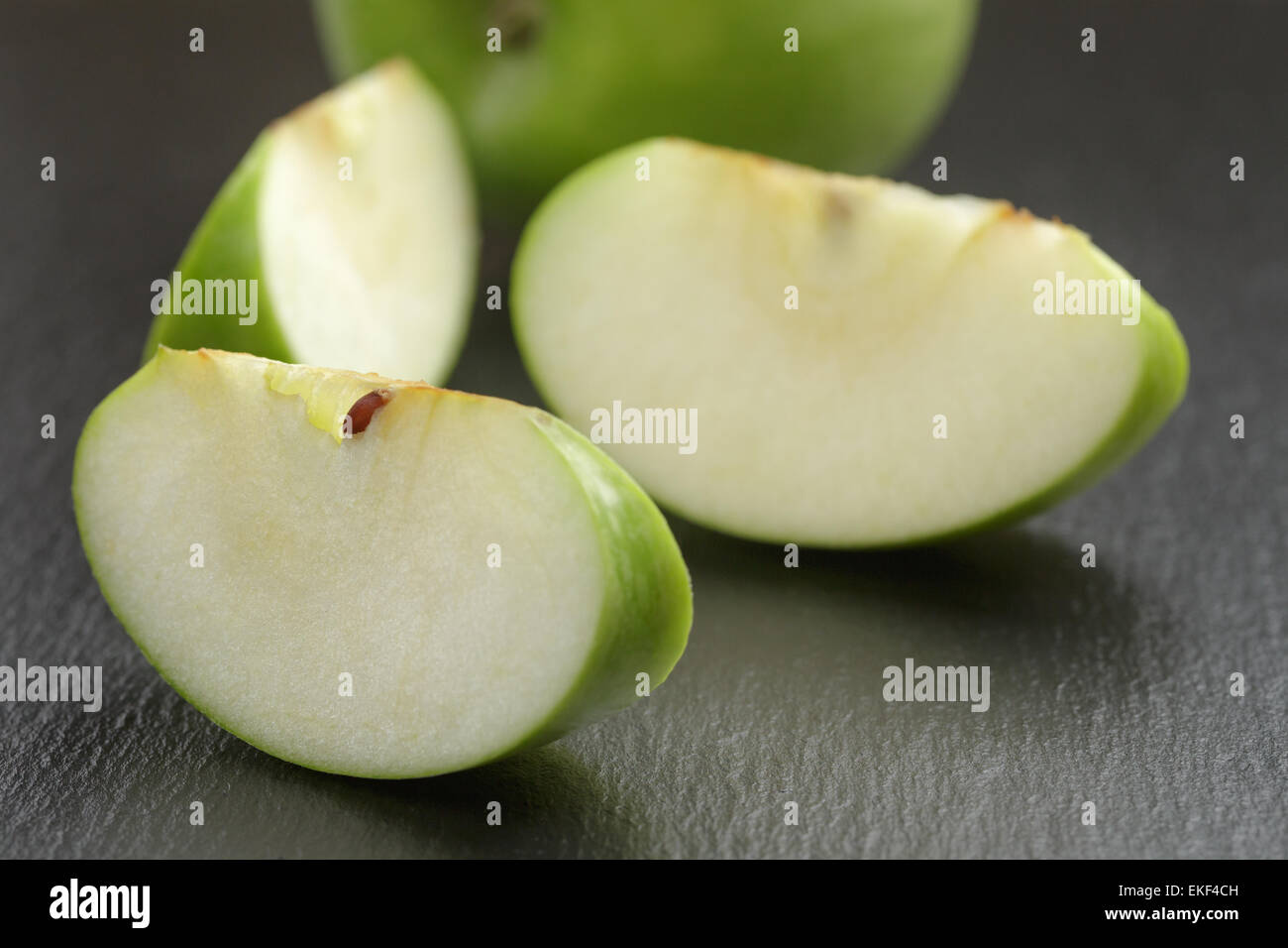 green sour apple on slate board sliced Stock Photo