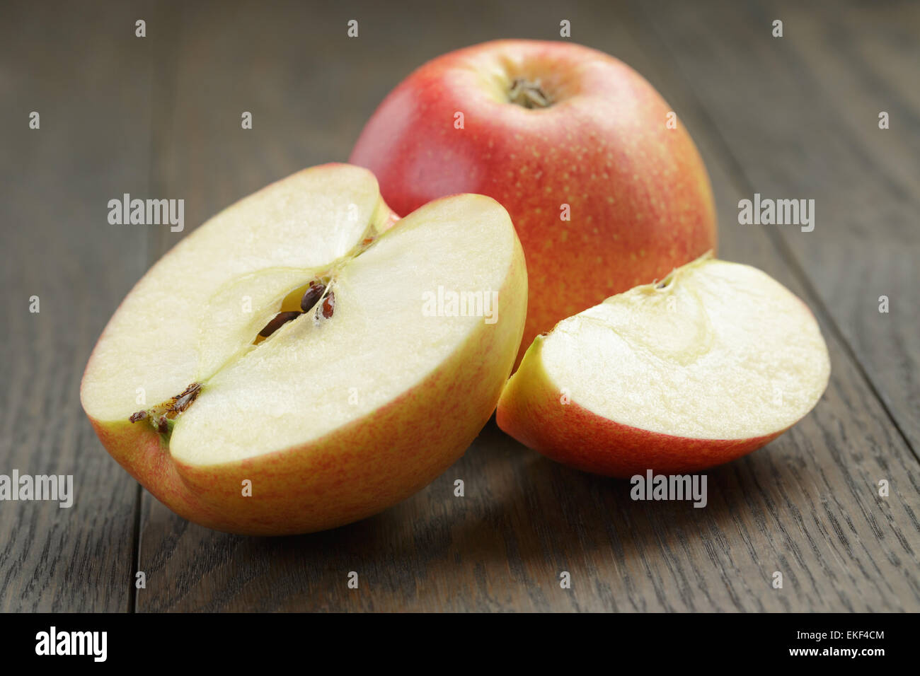 seasonal red apples sliced on wooden table Stock Photo