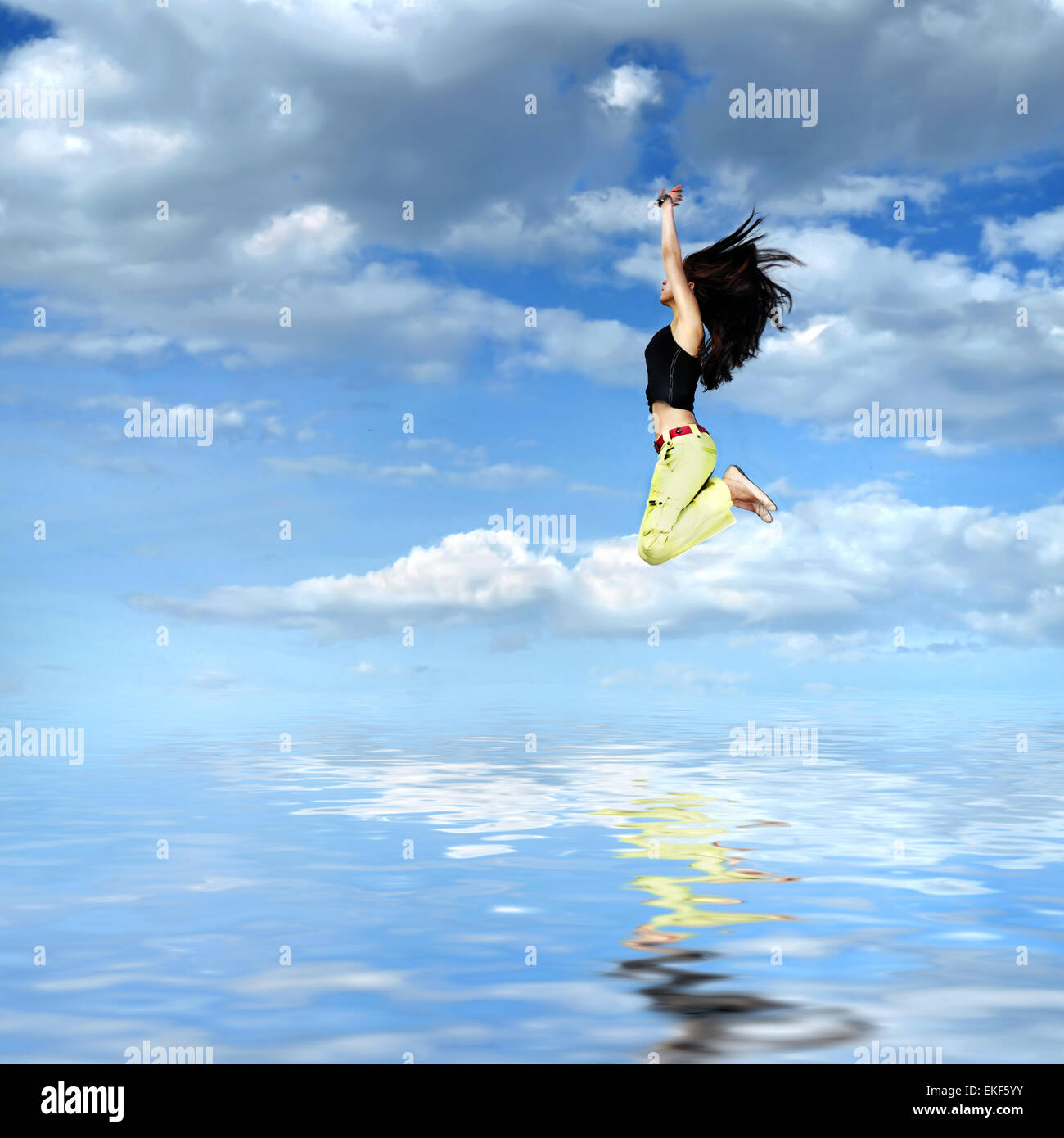 girl jumping against blue sky with water reflection Stock Photo - Alamy
