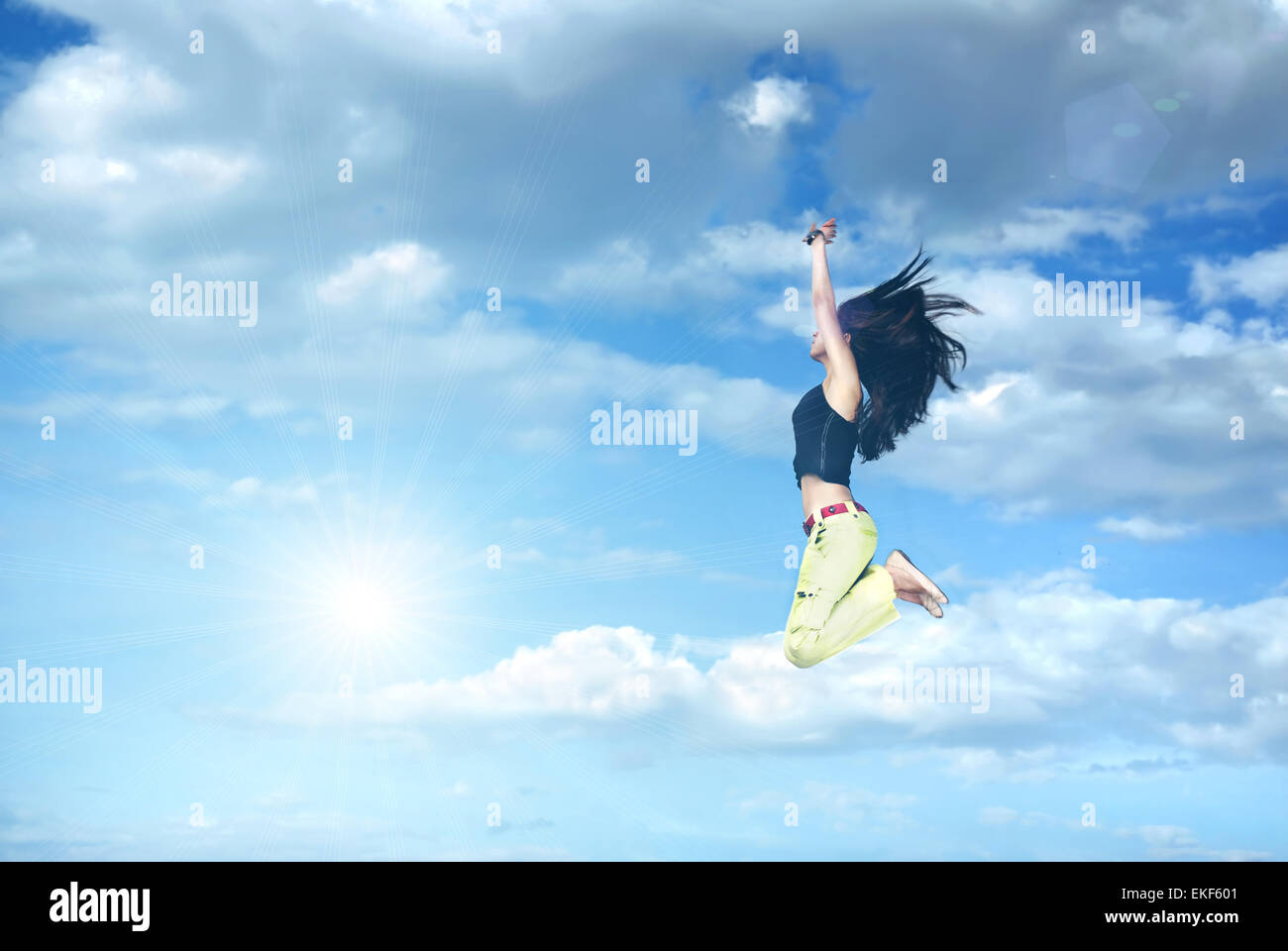 girl jumping against blue sky and sun Stock Photo - Alamy
