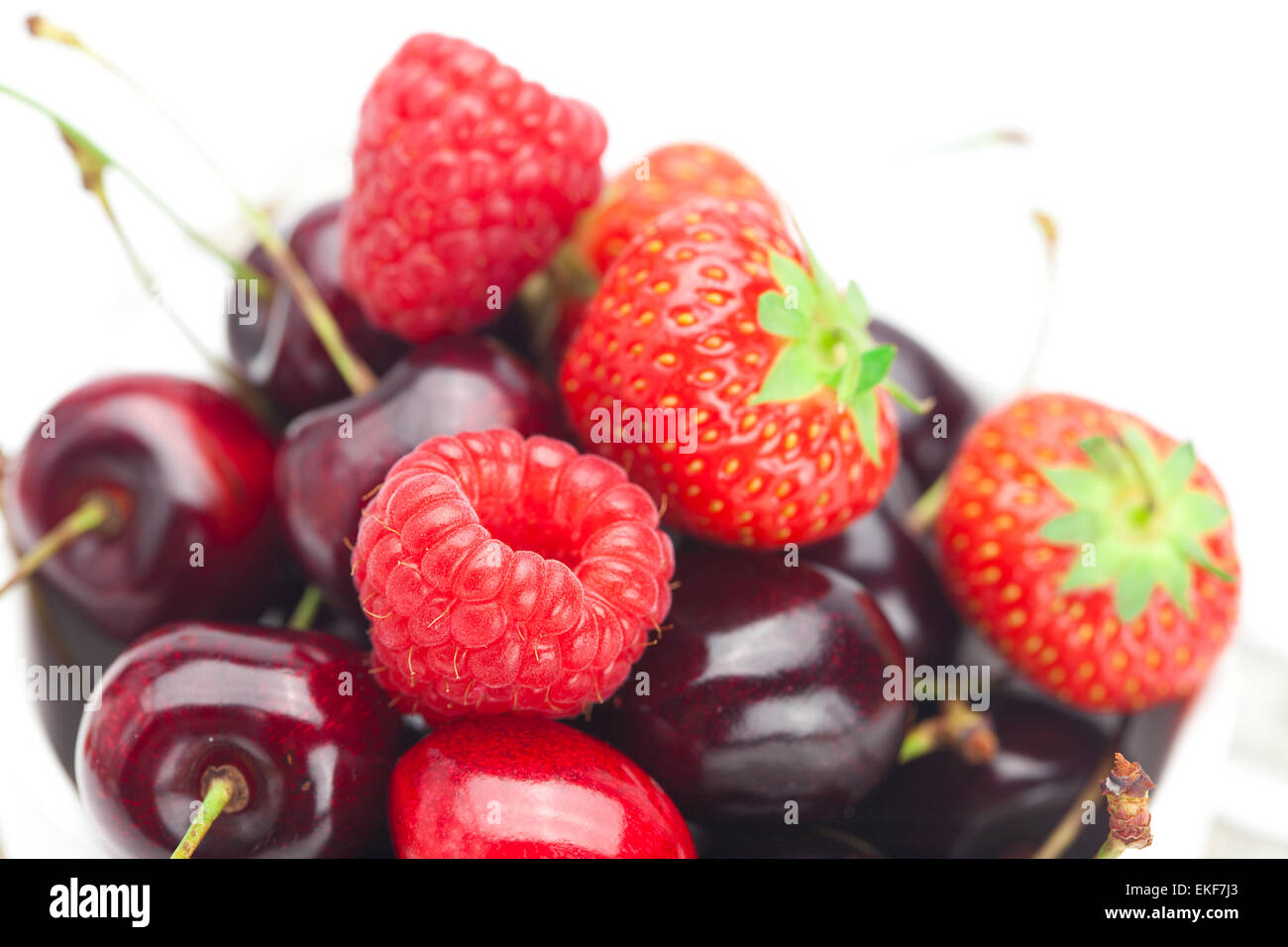 raspberries, strawberries and cherries in a bowl isolated on whi Stock ...