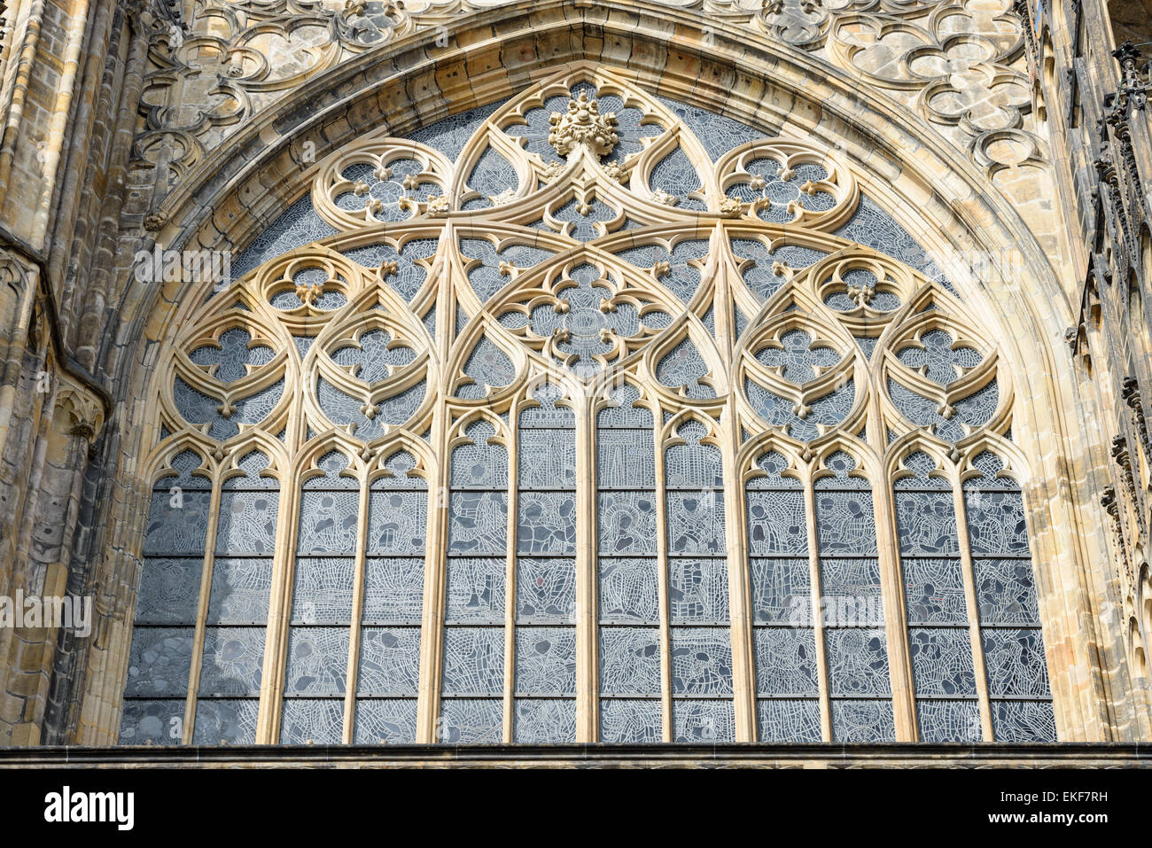 Exterior view of stained-glass window with tracery of cut stone in wide pointed arch above Golden Gate of St. Vitus Cathedral, P Stock Photo