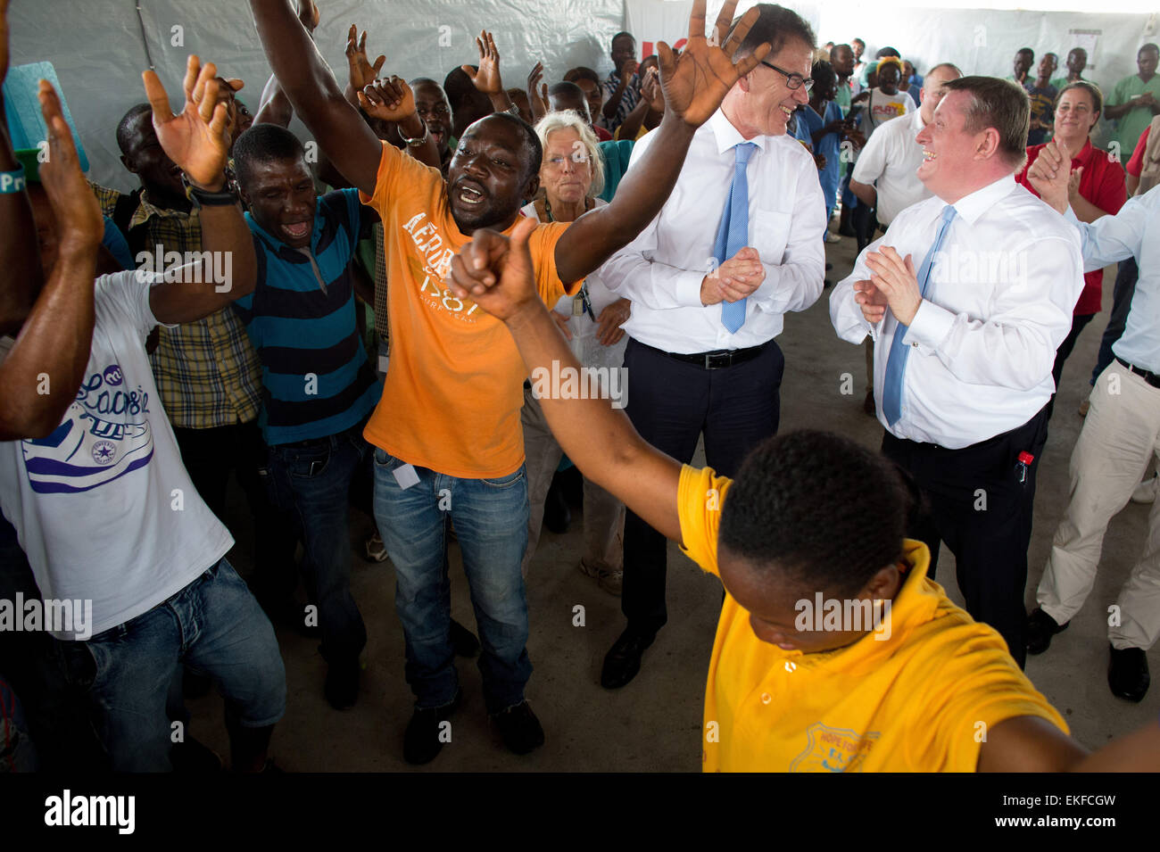 Monrovia, Liberia. 09th Apr, 2015. German Federal Minister of Health Hermann Groehe (R) and Minister of Development Gerd Mueller are welcomed with song and dance by volunteer Ebola helpers at the SITTU (Severe Infections Temporary Treatment Unit) in Monrovia, Liberia, 09 April 2015. German Federal Ministers Groehe and Mueller are traveling to Liberia and visiting the SITTU in order to discuss reconstruction after the Ebola epidemic. Photo: KAY NIETFELD/dpa/Alamy Live News Stock Photo