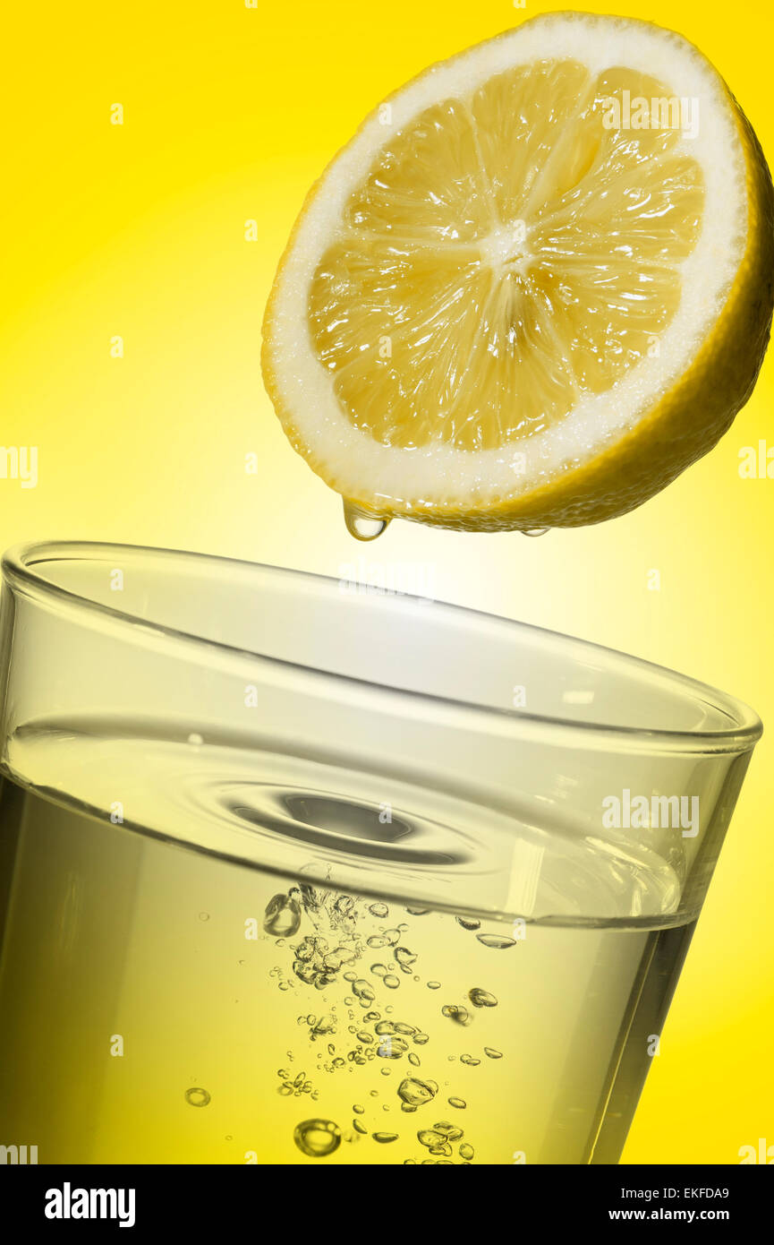 glass full of fresh water with lemon juice, on yellow background Stock Photo Alamy