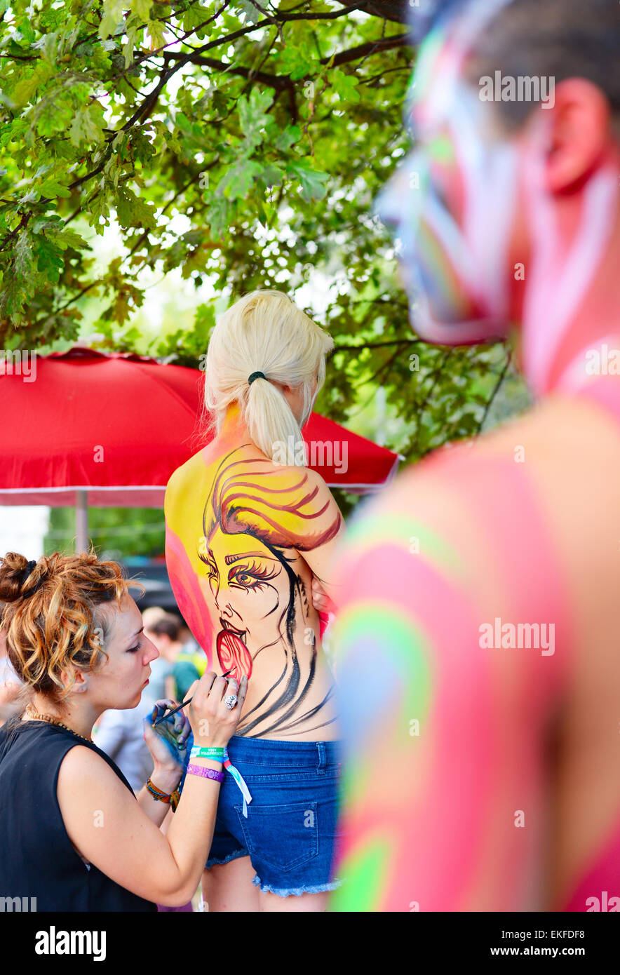 Woman making body-art during the Sziget festival. Sziget is one of biggest festivals in Euro Stock Photo