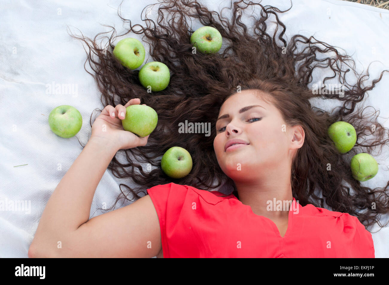Woman lying in wheat field with green apple. Picnic Stock Photo - Alamy