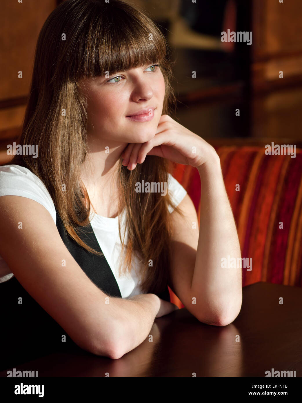 A young woman sitting in a cafe Stock Photo - Alamy