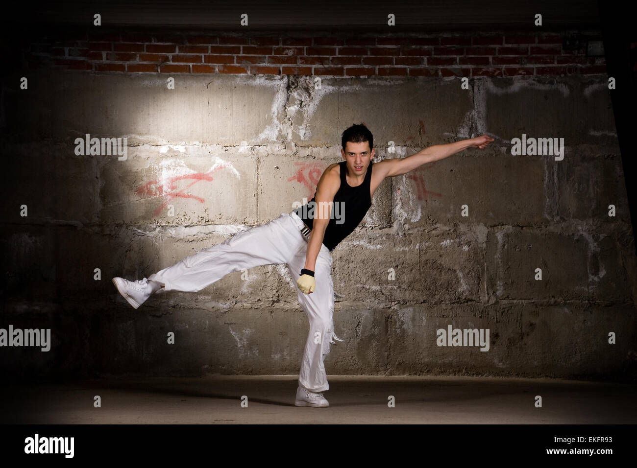 Hip hop boy dancing in modern style over grey brick wall Stock Photo