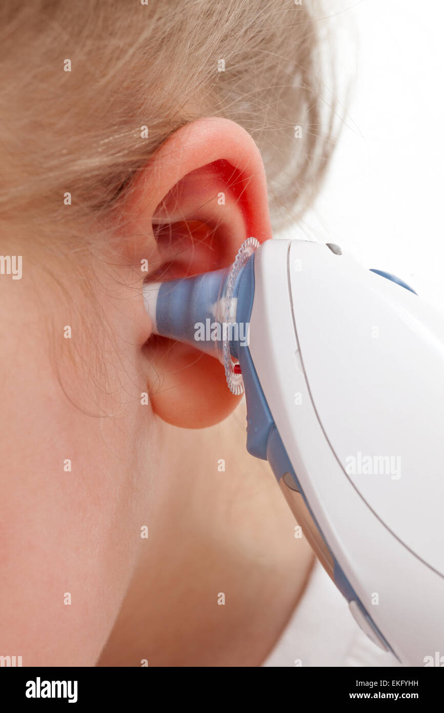 Taking temperature with ear thermometer Stock Photo