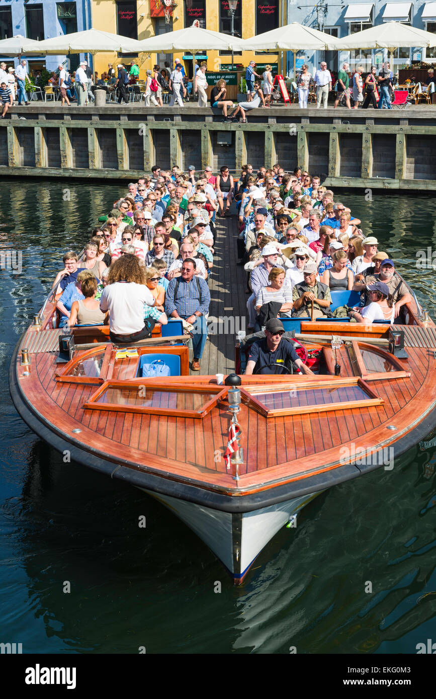 A canal and harbour tour cruise boat turns in Nyhavn, Copenhagen, Denmark. Stock Photo