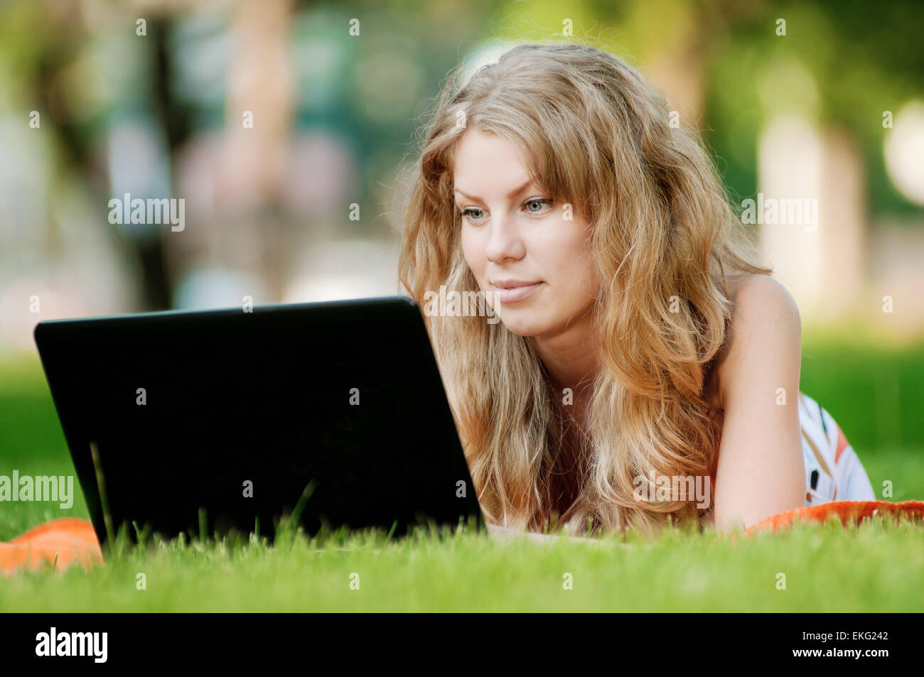 Young woman with laptop at park Stock Photo - Alamy