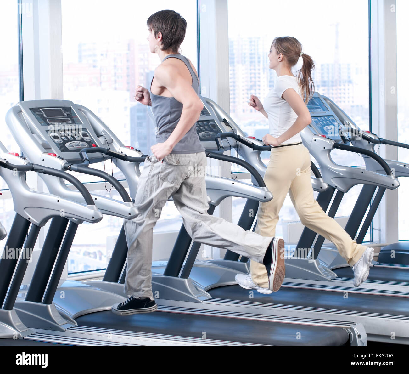 Young woman and man at the gym exercising. Running Stock Photo - Alamy