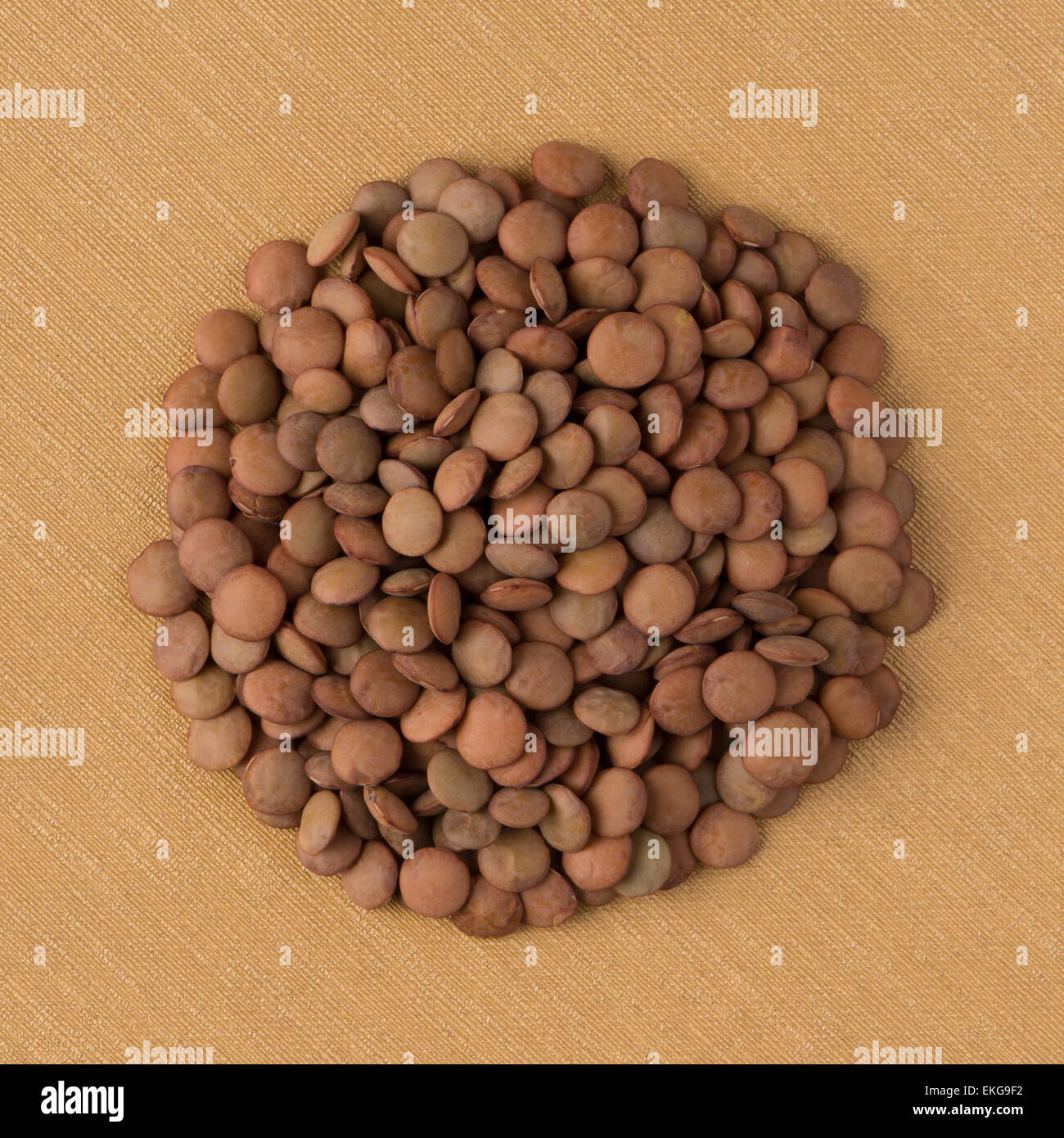 Top view of circle of lentils against yellow vinyl background Stock