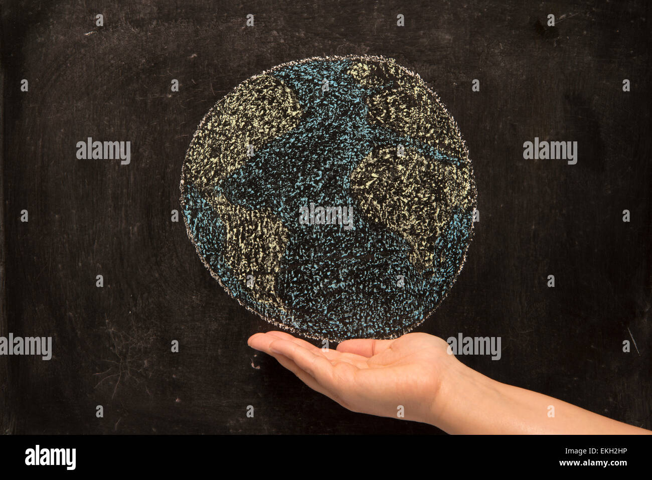 holding the world on blackboard Stock Photo