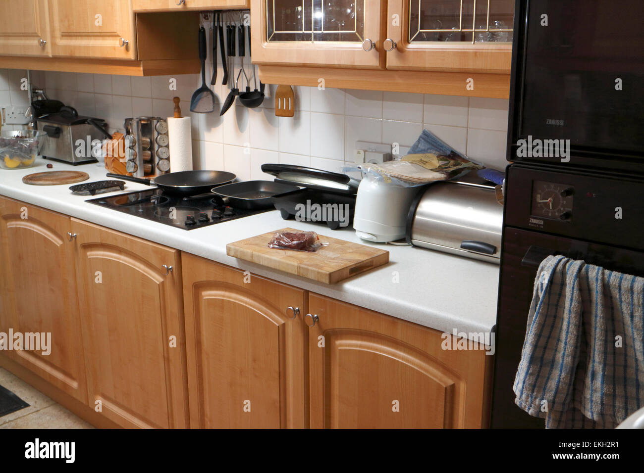 household kitchen with wooden doors and white worktops Stock Photo