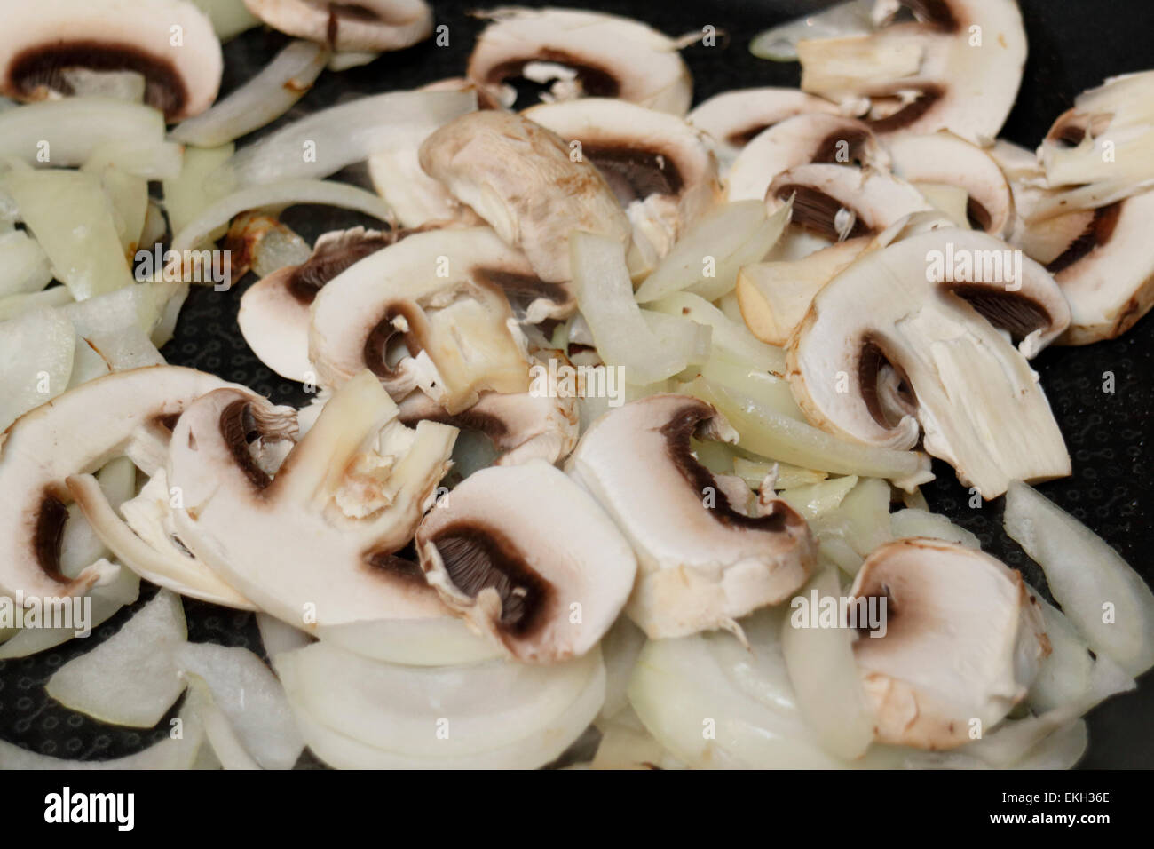 frying sliced cut chopped onions and mushrooms Stock Photo