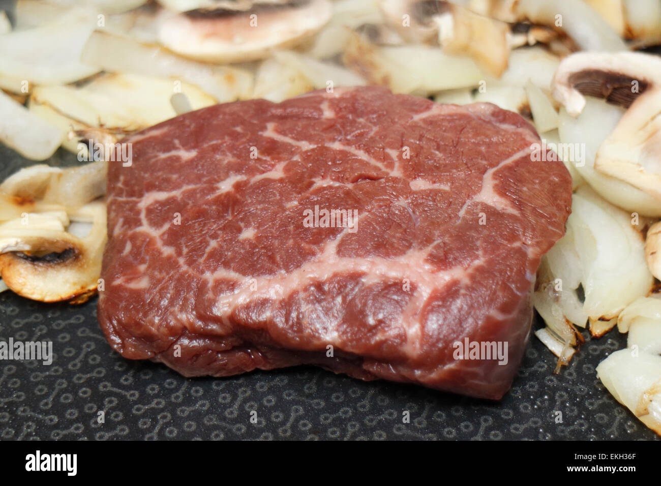 frying bison steak with mushrooms and onions Stock Photo