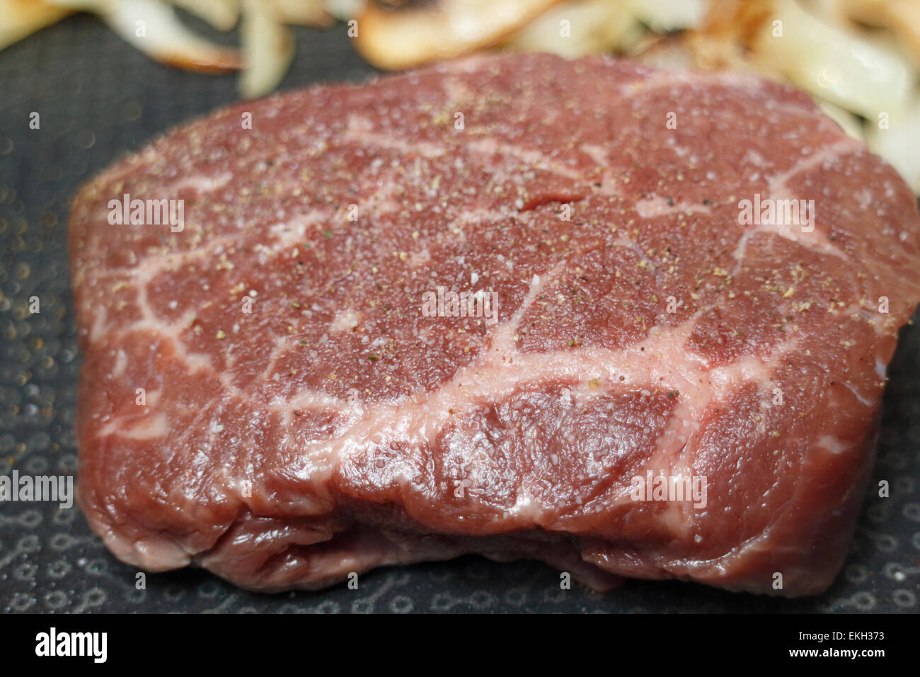 frying seasoned bison steak with mushrooms and onions Stock Photo