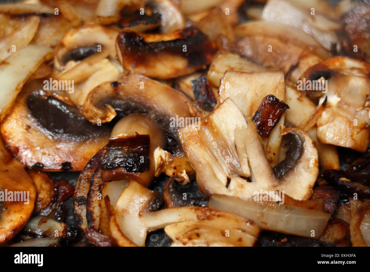 browning frying sliced cut chopped onions and mushrooms Stock Photo