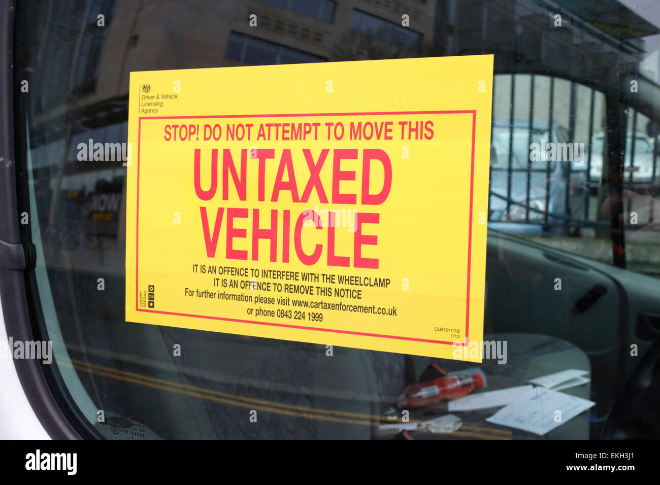 warning sticker attached to window of vehicle clamped for unpaid vehicle tax Stock Photo