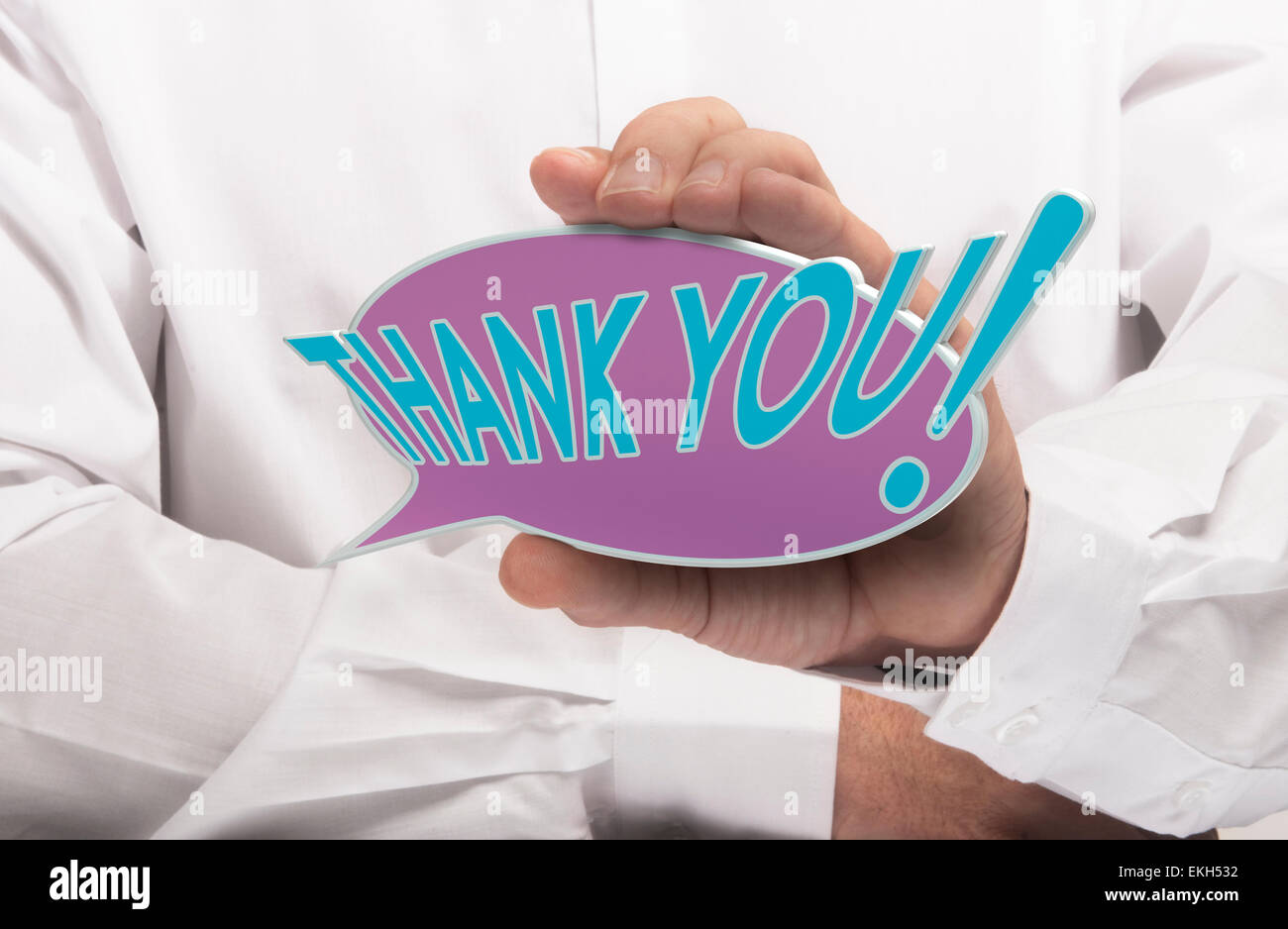 Image of a man hand holding speech balloon with the text thank you, white shirt. Concept for acknowledgement and thanks. Stock Photo