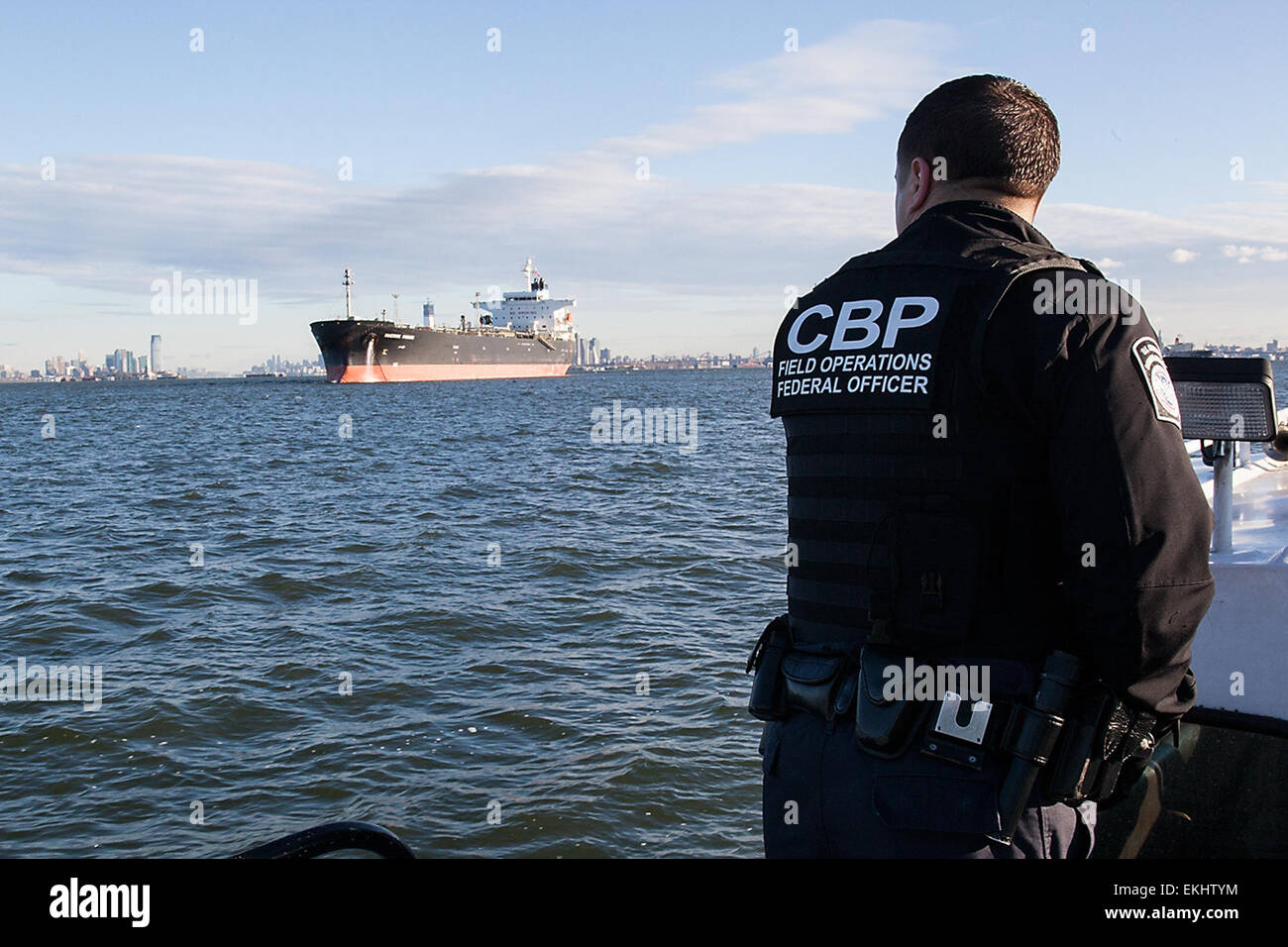 110312: Port of New York / Newark -   A U.S. Customs &amp; Border Protection Officer looks out at the fuel tanker that he and another officer are about to board and do a crew immigration inspection on.   Josh Denmark Stock Photo