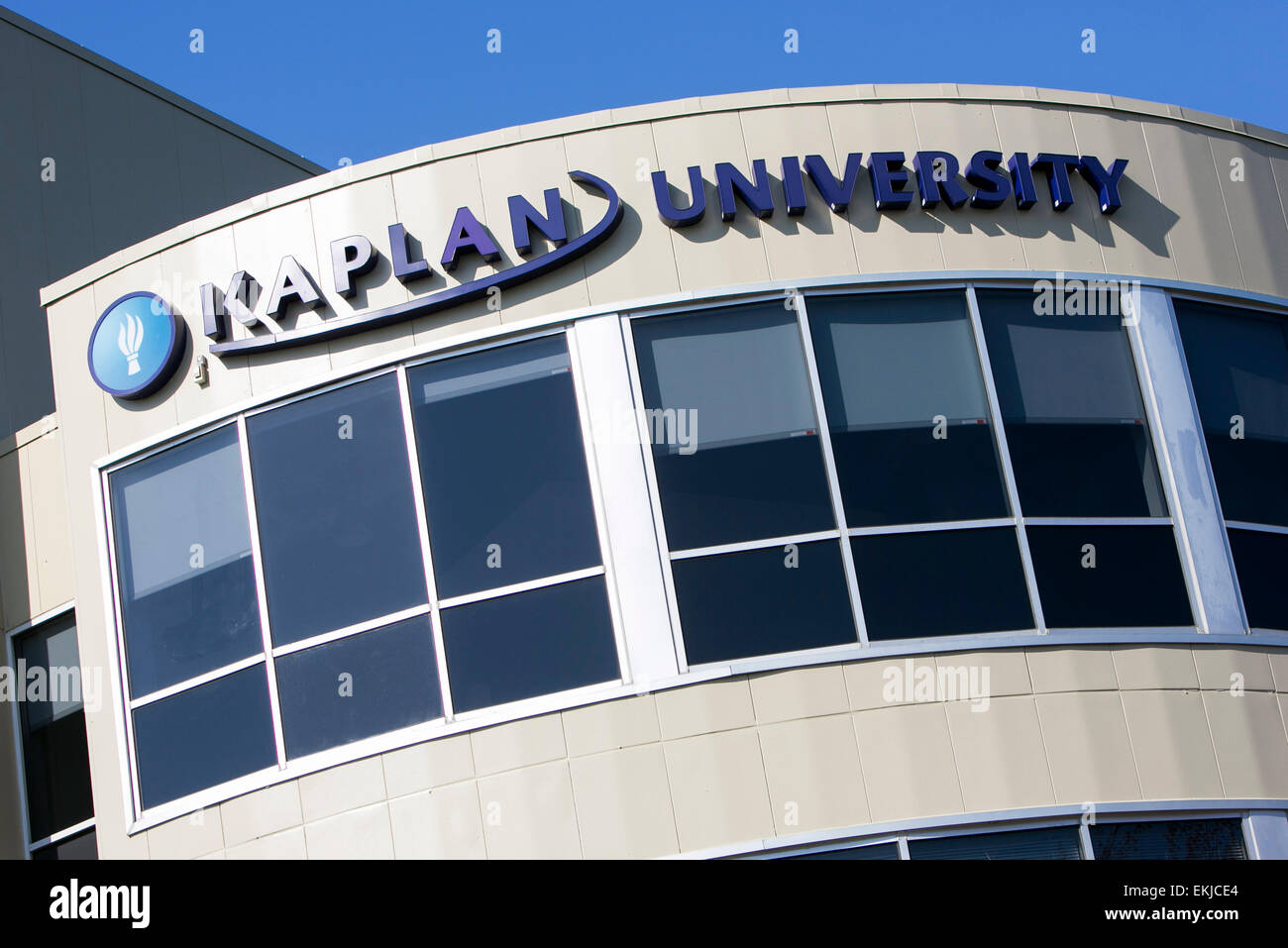 A logo sign on a building occupied by Kaplan University. Stock Photo