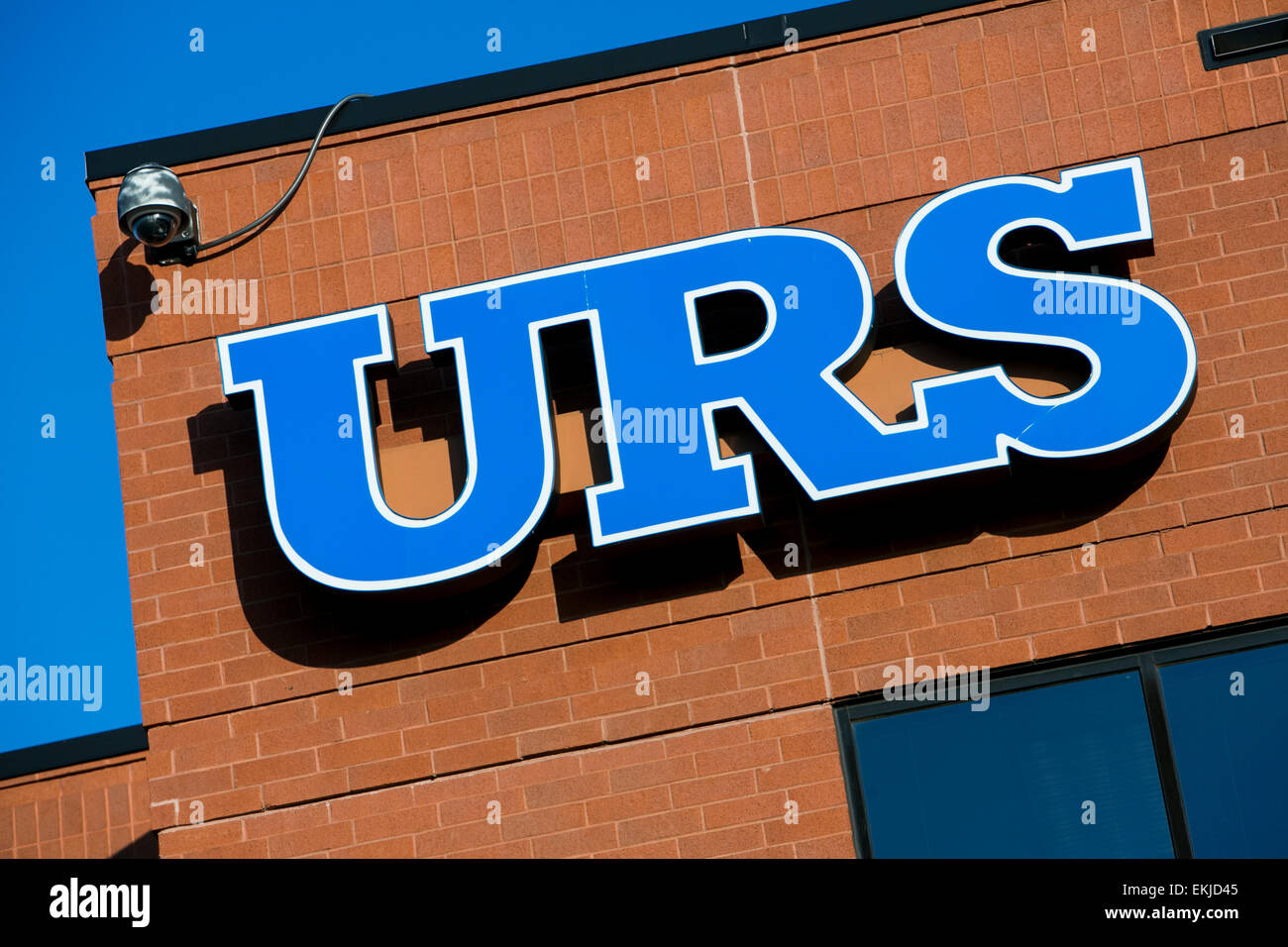 A logo sign outside outside of a building occupied by URS. Stock Photo
