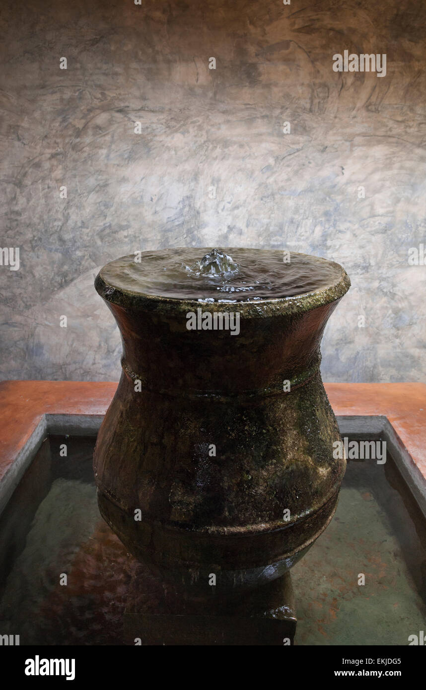 Garden water feature, earthenware pot with bubbling water overflowing Stock Photo