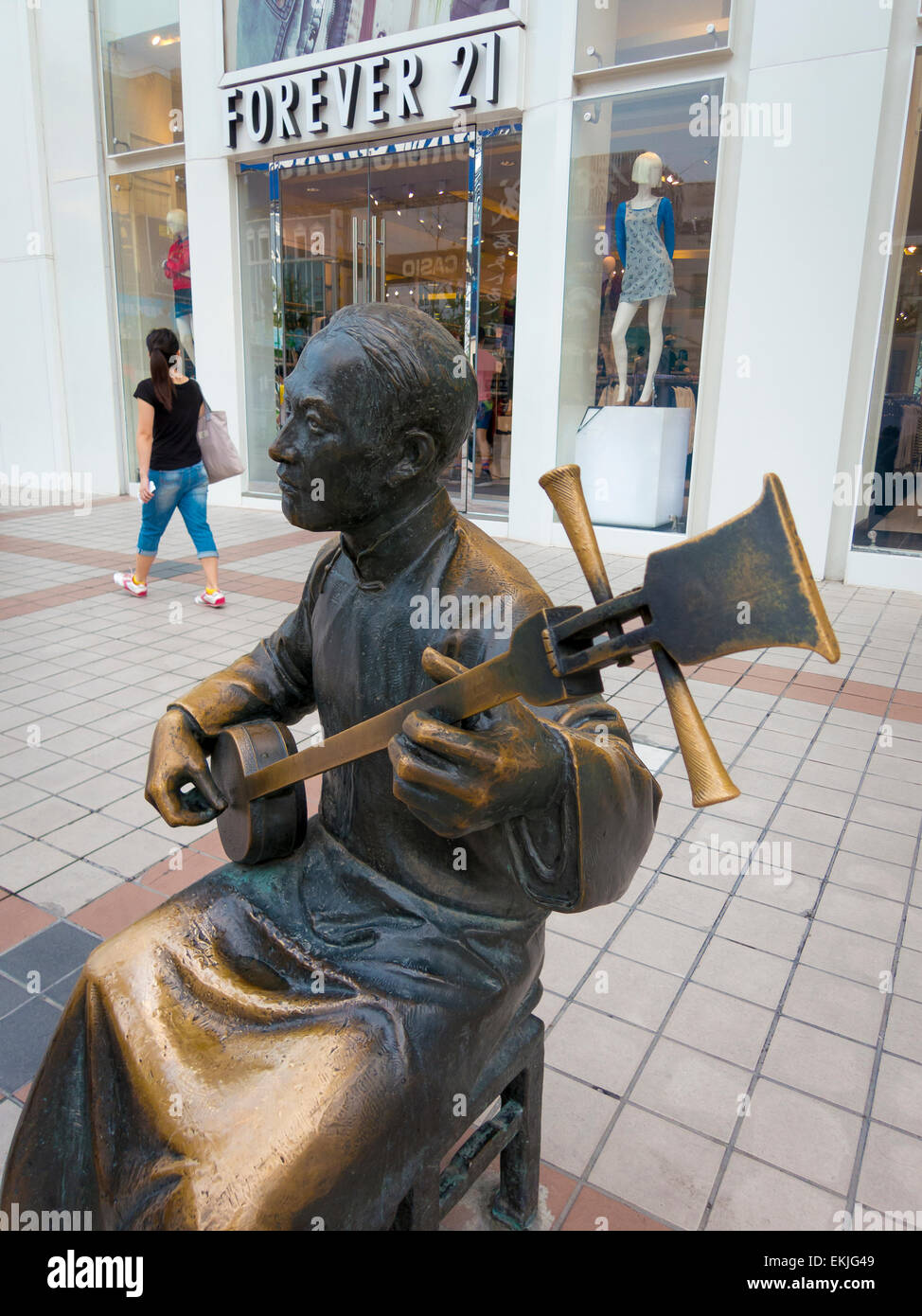 Bronze statues of traditional musicians in fron of Western stores lining Wafujing Street