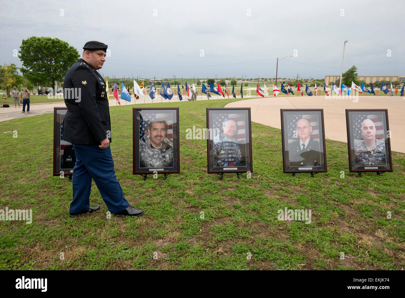Soldier wounded in 2009 terrorist attack at Fort Hood TX stands before portraits of those killed in attack at memorial service Stock Photo