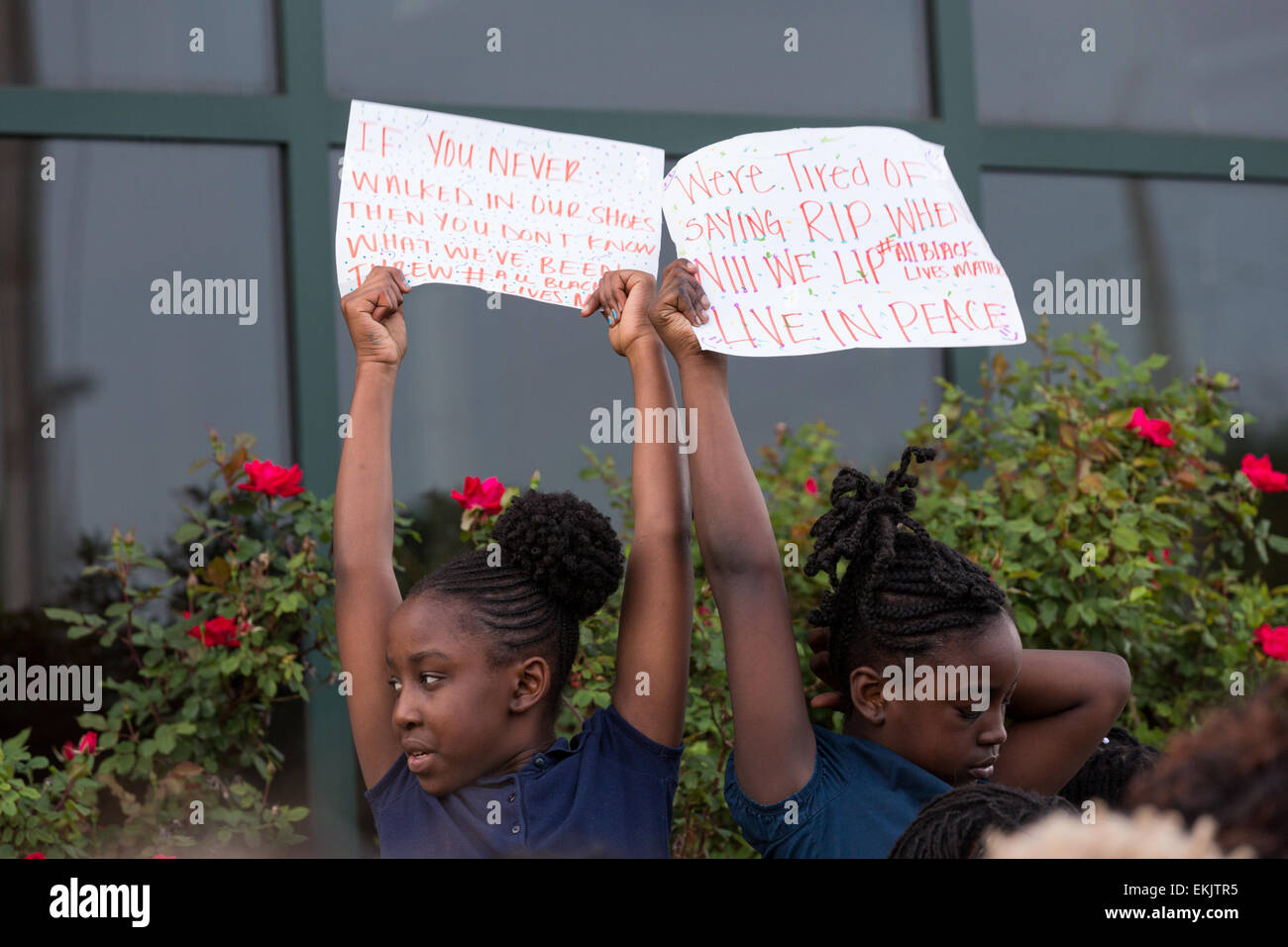 Young girls hold a sign during a vigil outside the North Charleston City Hall following the shooting death of Walter Scott April 10, 2015 in Charleston, South Carolina. Scott was shot multiple times by police after running from a traffic stop. Stock Photo