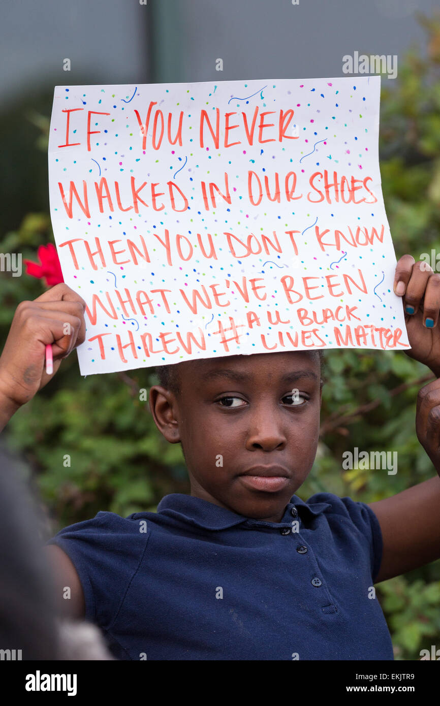 A young girl hold a sign during a vigil outside the North Charleston City Hall following the shooting death of Walter Scott April 10, 2015 in Charleston, South Carolina. Scott was shot multiple times by police after running from a traffic stop. Stock Photo