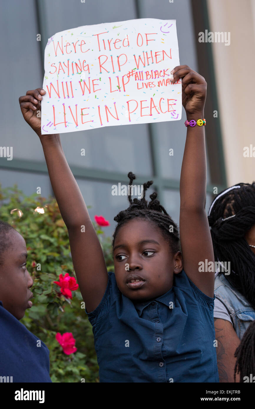 A young girl hold a sign during a vigil outside the North Charleston City Hall following the shooting death of Walter Scott April 10, 2015 in Charleston, South Carolina. Scott was shot multiple times by police after running from a traffic stop. Stock Photo