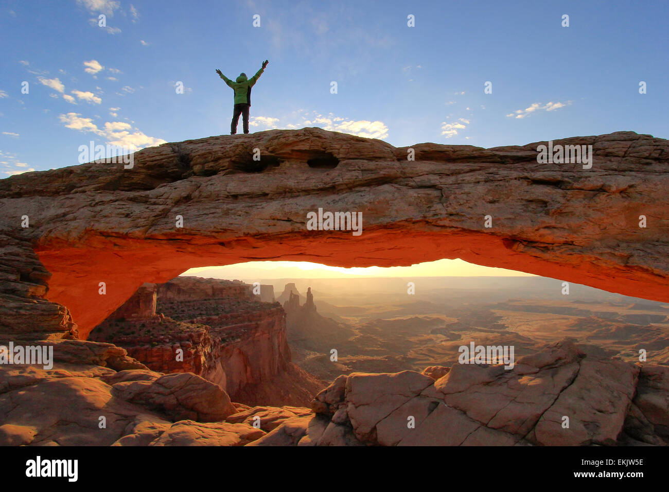 Silhouetted person standing on top of Mesa Arch, Canyonlands National Park, Utah Stock Photo