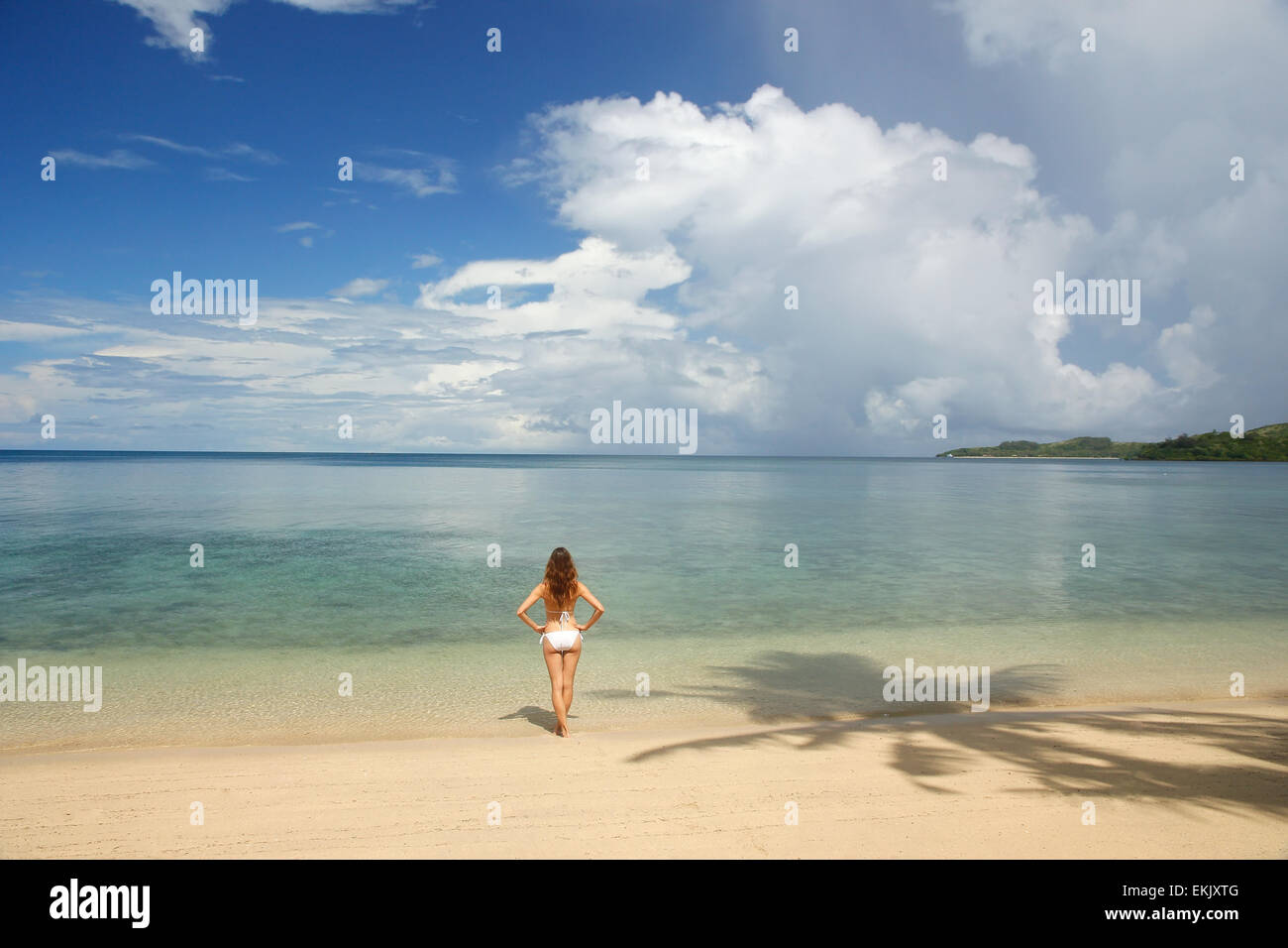 Young woman in bikini standing on a tropical beach, Nananu-i-Ra island, Fiji, South Pacific Stock Photo