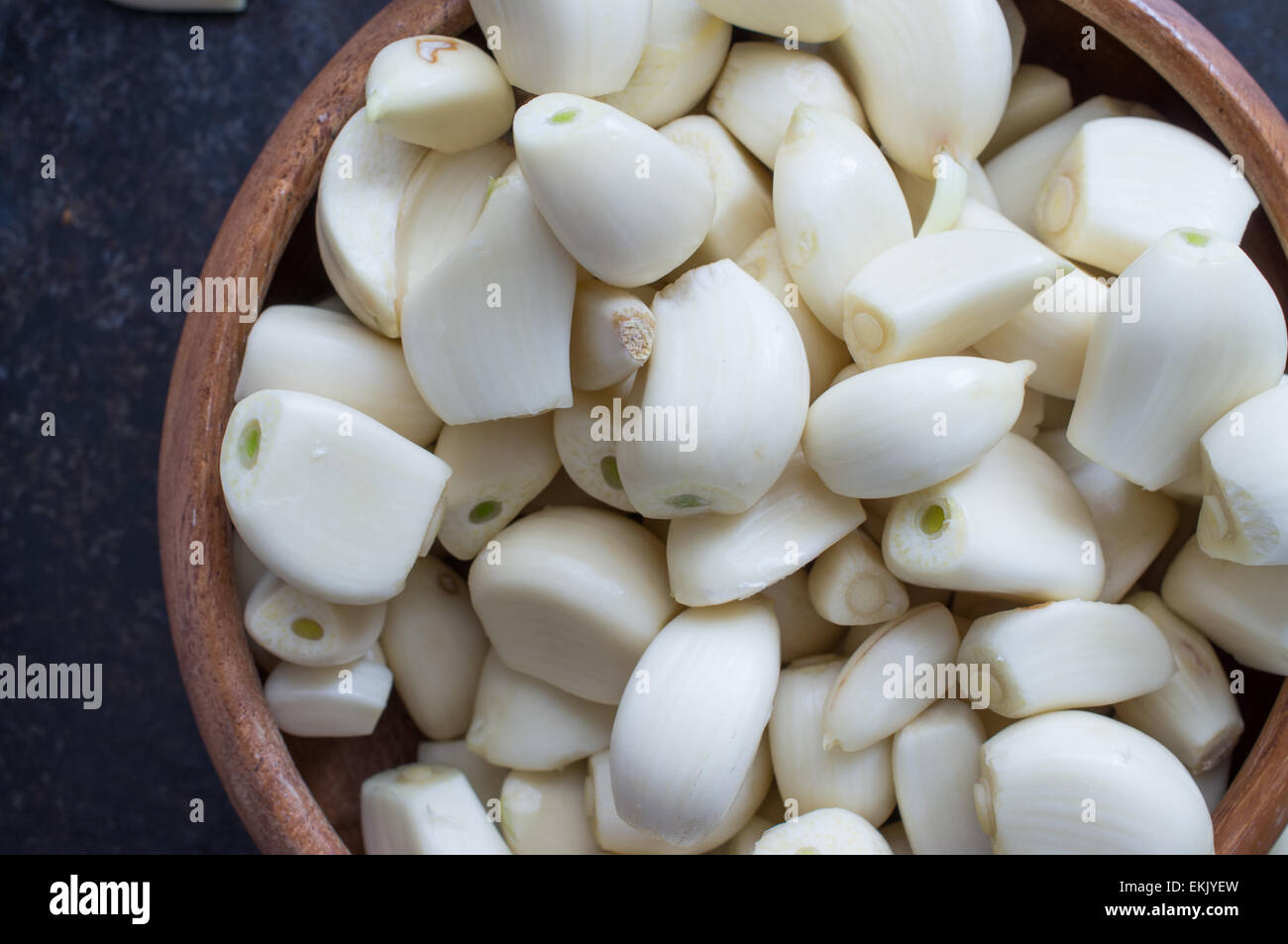 Peeled garlic cloves close up in a wooden bowl Stock Photo - Alamy